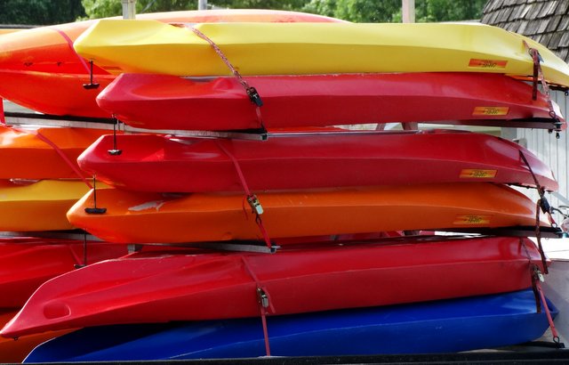 A pile of colorful kayaks
