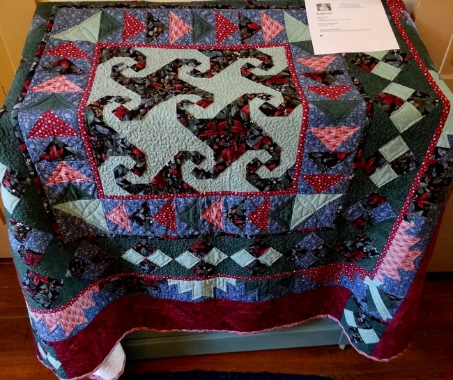 This one uses a variety of quilt patterns too.  I believe the center is called "Drunkard's Path".  The frame around the center looks like "Flying Geese".  The next frame looks like a "Four Patch" design.  I'm not sure what the next frame is.  It kind of looks like a "Bear Paw".  I like how the quilter combined the patterns.