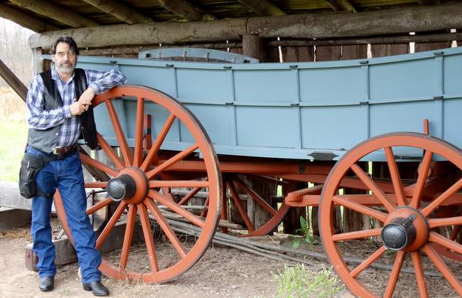 Mark leaning on a wagon wheel