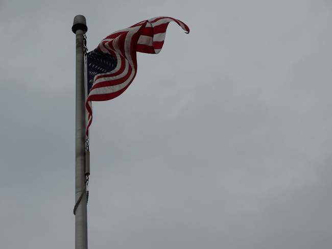 The American flag flew on a higher pole than the other four.