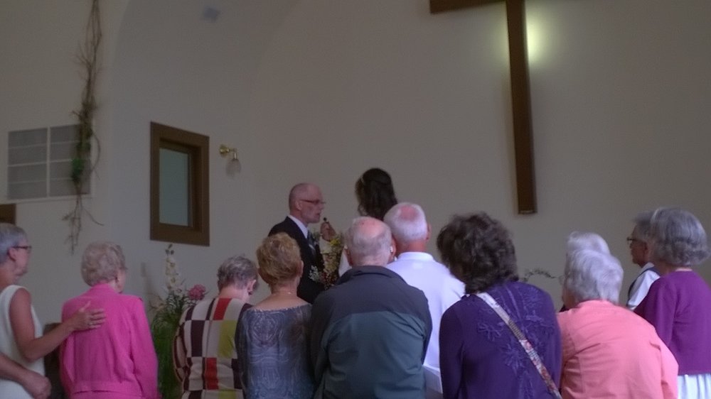 The pastor called all the church members who wanted to support the couple to come forward as they said their vows.  All of us except Mark went forward.  Mark took this shot.  (I'm the curly-headed one in purple.)